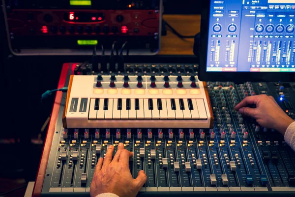 男性のサウンドエンジニア プロデューサー 作曲家の手録音スタジオでオーディオミキサーで音楽をミキシング — ストック写真