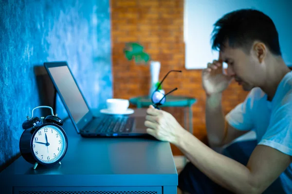 夜の寝室でノートパソコンの仕事をしているアジア系の青年が — ストック写真