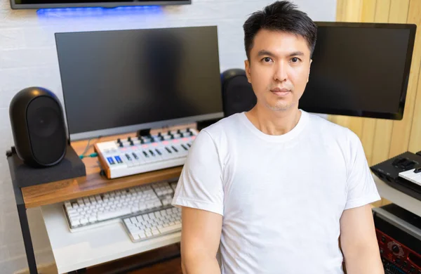 asian smart, healthy music composer smiling in home studio