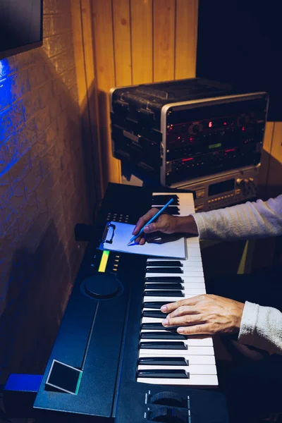 男性ソングライターがエレキピアノを弾いて夜にホームスタジオで曲を書いて — ストック写真