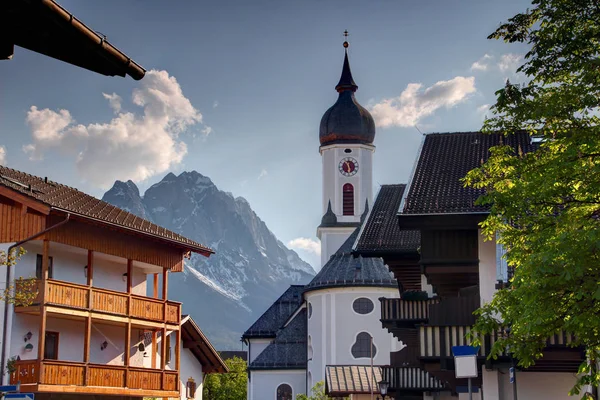 Chiesa e case di Garmisch con vetta Zugspitze in Baviera — Foto Stock