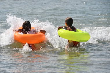 Anapa, Rusya, Temmuz, 18, 2018. Karadeniz Inn Anapa dalgalar halinde şişme çevrelerde arkasından iki kız banyo