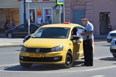 Moskova, Rusya, Ağustos, 12, 2018. Trafik polis memuru bir taksi şoförü, Moskova büyük Sukharevskaya meydanında belgeleri denetler