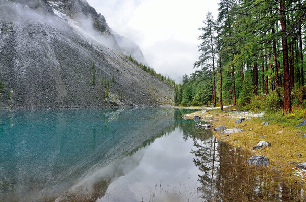 Russia, Mountain Altai. Big Shavlinskoye lake in foggy weather