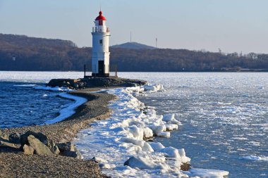 Rusya. Vladivostok. Egersheld (1876 Yapim yili) deniz feneri Shkot Yarımadası - kış akşamları Tokarevskaya koshka ucunda