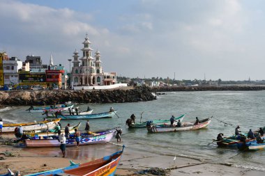 Cape Comorin (Kanyakumari), Hindistan, Batı Bengal (Tamil Nadu), Mart, 15, 2019. Fisherfolk plaj ve Aziz Arockia Nathar Kilisesi iyon cape Comorin (Kanyakumari), Hindistan, Tamil Nadu balıkçılık deniz araçları üzerinde