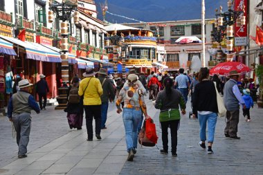 Tibet, Lhasa, Çin, 02 Haziran 2018. Bulutlu havalarda bir yaz gününde antik Barkhor sokak boyunca yürüyen insanlar
