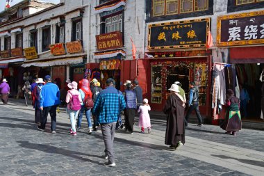 Tibet, Lhasa, Çin, 02 Haziran 2018. Bulutlu havalarda bir yaz gününde antik Barkhor sokak boyunca yürüyen insanlar