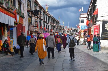 Tibet, Lhasa, Çin, 02 Haziran 2018. Bulutlu havalarda bir yaz gününde antik Barkhor sokak boyunca yürüyen insanlar