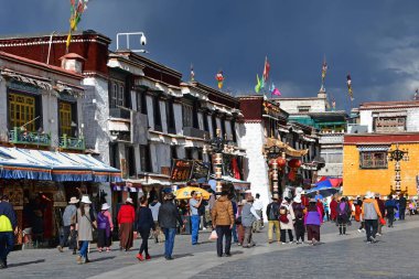 Tibet, Lhasa, Çin, 02 Haziran 2018. Bulutlu havalarda bir yaz gününde antik Barkhor sokak boyunca yürüyen insanlar