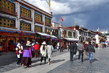 Tibet, Lhasa, Çin, 02 Haziran 2018. Bulutlu havalarda bir yaz gününde antik Barkhor sokak boyunca yürüyen insanlar