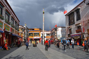 Tibet, Lhasa, Çin, 02 Haziran 2018. Bulutlu havalarda bir yaz gününde antik Barkhor sokak boyunca yürüyen insanlar