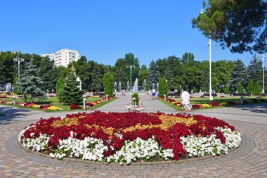 Anapa, Rusya, 14 Temmuz 2018. İnsanlar Anapa Sovyetler meydanında güzel çiçek yatağı yakınında yürüyüş