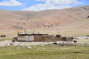 Tibet. Yaz aylarında Gomang Gölü'ne çok uzak olmayan yüksek dağ köyü