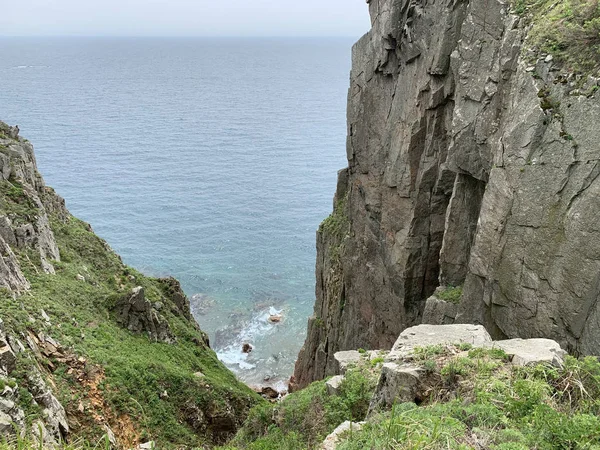 Rusya, Vladivostok. Yaz sabahı Shkot adasının Güney-Doğu kıyıları. Küçük bir mağaranın girişi ile Kaya