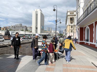 Vladivostok, Rusya, 22 Mayıs 2019. İnsanlar yeraltı yaya geçidinden çıkıp Svetlanskaya caddesindeki vadinin satıcı zambaklarının yanından geçiyorlar.