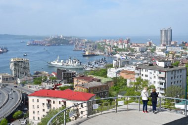 Vladivostok, Rusya, 21 Mayıs 2019. İlkbaharda gözlem güvertesinden şehre bakan iki kadın 