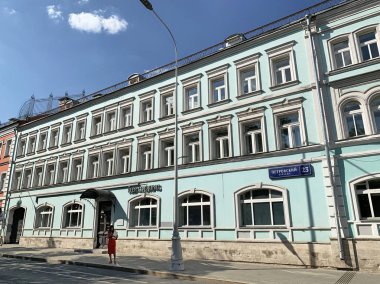 Moskova, Rusya, Haziran. 20, 2019. Moskova'da Petrovsky Bulvarı'nda yaz aylarında eski evin yakınında yürüyen kadın 23