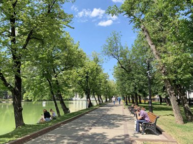 Moskova, Rusya, 20 Haziran 2019. İnsanlar güneşli Haziran gününde Chistoprudny Bulvarı'nda banklarda rahatlatıcı