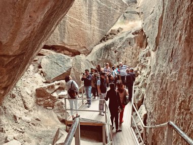 Gobustan, Azerbaycan, 11 Eylül 2019. Bulutlu havalarda sonbaharda Gobustan devlet tarihi ve sanat rezerv toprakları boyunca yürüyen insanlar