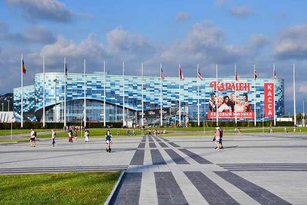 Sochi, Rusya, Ağustos, 10, 2019, İnsanlar yaz aylarında Soçi Olimpiyat Parkı 'ndaki Buz Sarayı' nın yakınında yürüyorlar.