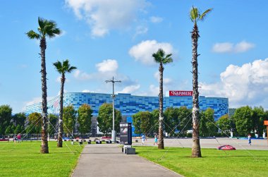 Sochi, Rusya, Ağustos, 10, 2019. Olimpik Park 'ta palmiye ağaçlarıyla yürüyen insanlar. Sochi, Adler.