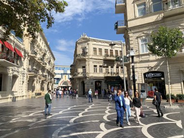 Bakü, Azerbaycan, Eylül, 09: 19. Eylül 'de Bakü' deki tarihi binaların yakınlarındaki Çeşme Meydanı 'nda yürüyen insanlar