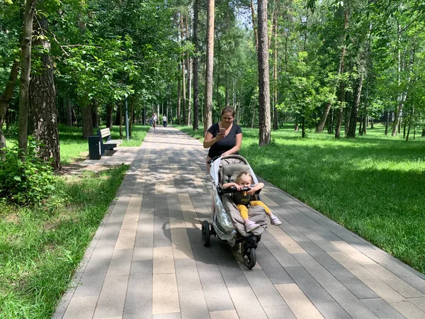 Balashikha Moscow Region Russia June 2020年 年轻的妈妈带着孩子坐在婴儿车里在公园里散步 — 图库照片