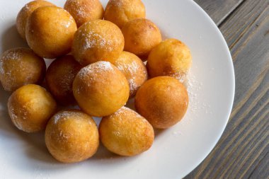 Top beyaz plaka ve ahşap arka plan üzerinde çörek şeklinde