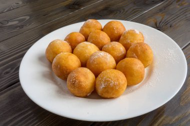 Top beyaz plaka ve ahşap arka plan üzerinde çörek şeklinde