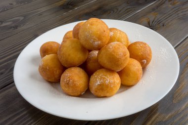 Top beyaz plaka ve ahşap arka plan üzerinde çörek şeklinde