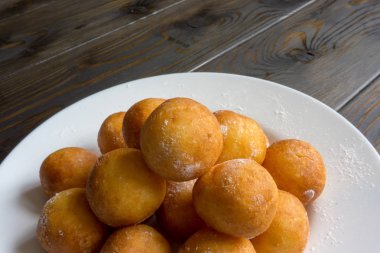 Top beyaz plaka ve ahşap arka plan üzerinde çörek şeklinde