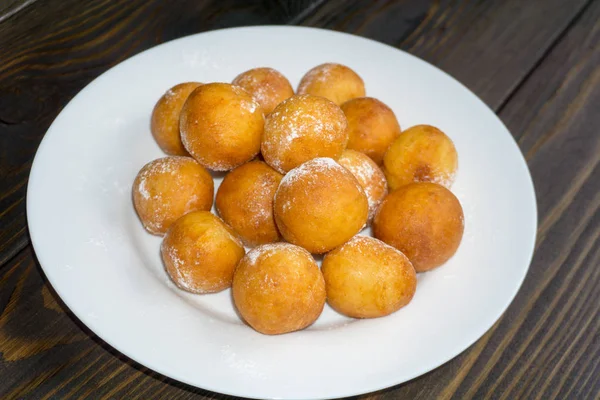 Rosquillas Forma Bola Placa Blanca Fondo Madera —  Fotos de Stock