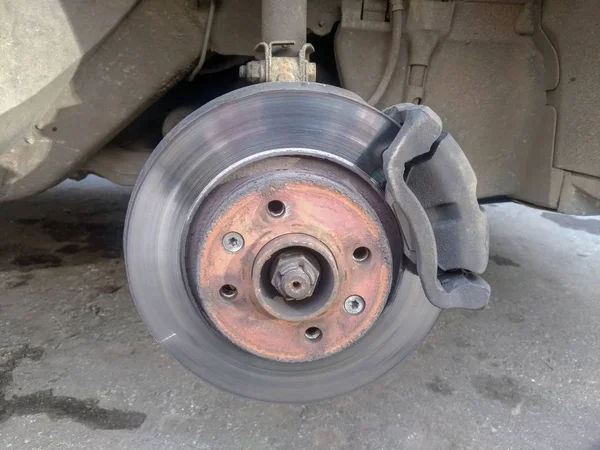 worn car brake disc and car caliper