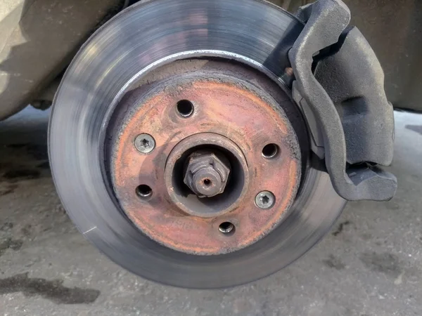 worn car brake disc and car caliper