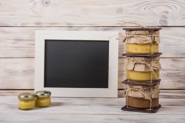 Hafif ahşap arka plan üzerinde bir cam kavanoza tatlım. Arı bal