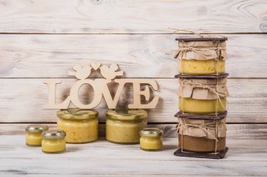 Hafif ahşap arka plan üzerinde bir cam kavanoza tatlım. Arı bal