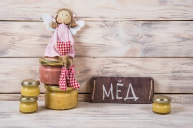 Hafif ahşap arka plan üzerinde bir cam kavanoza tatlım. Arı bal