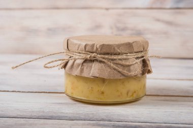 Hafif ahşap arka plan üzerinde bir cam kavanoza tatlım. Arı bal