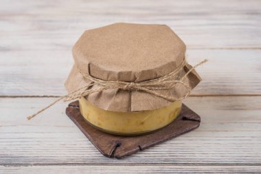 Hafif ahşap arka plan üzerinde bir cam kavanoza tatlım. Arı bal