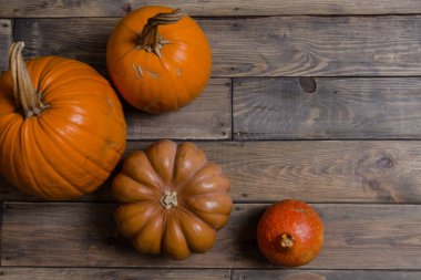 Dokulu arka plan. Karanlık panoları. Sonbahar renkleri. Kabaklar ahşap bir masa üzerinde. Eski ahşap