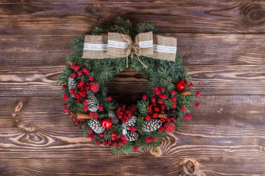 Noel Kış koyu ahşap arka plan karede. Noel çelenk. Kırmızı öğeler