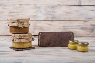 Hafif ahşap arka plan üzerinde bir cam kavanoza tatlım. Arı bal