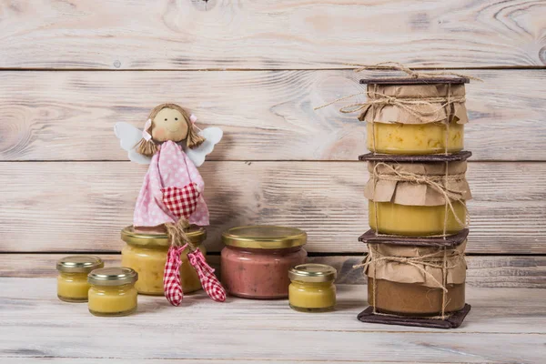 Hafif ahşap arka plan üzerinde bir cam kavanoza tatlım. Arı bal