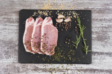 Baharat ile taze çiğ et parçaları. Et ahşap masanın üzerine dilimlenmiş