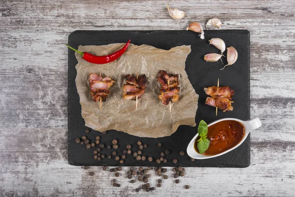 Pieces of roasted meat. Snack. Meat in sweet and sour sauce on the wooden table