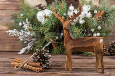 Çelenk. Noel Kış koyu ahşap arka plan karede. Çam kozalakları ve pamuk. Ahşap oyuncak geyik
