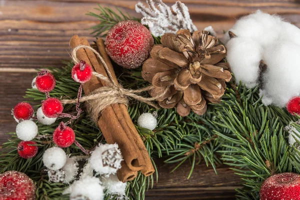 Wreath. Christmas winter frame on dark wooden background. Red elements