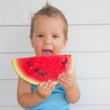 Çocuk bir karpuz yiyor. Summer, watermelo olan bir çocuk