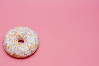 pembe bir arka planda beyaz buzlanma ile donut. Bir donut serpilir